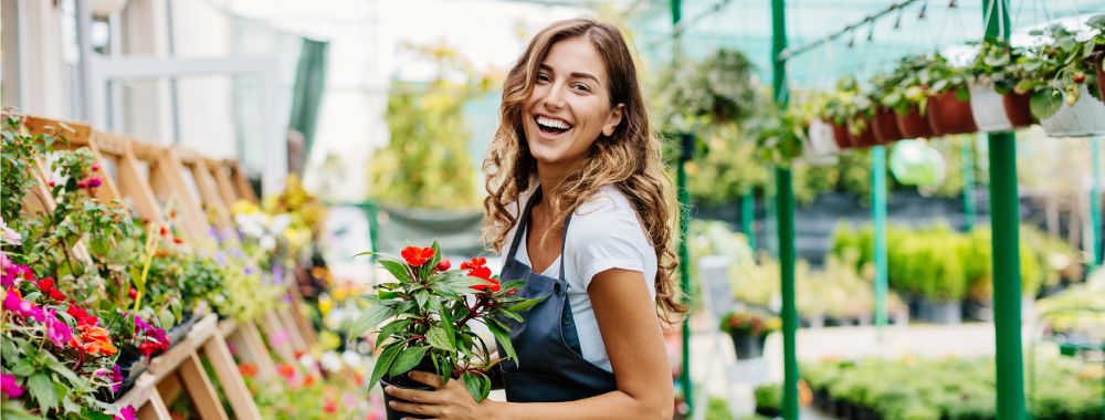 jeune fille souriante pendant son job d'été de fleuriste